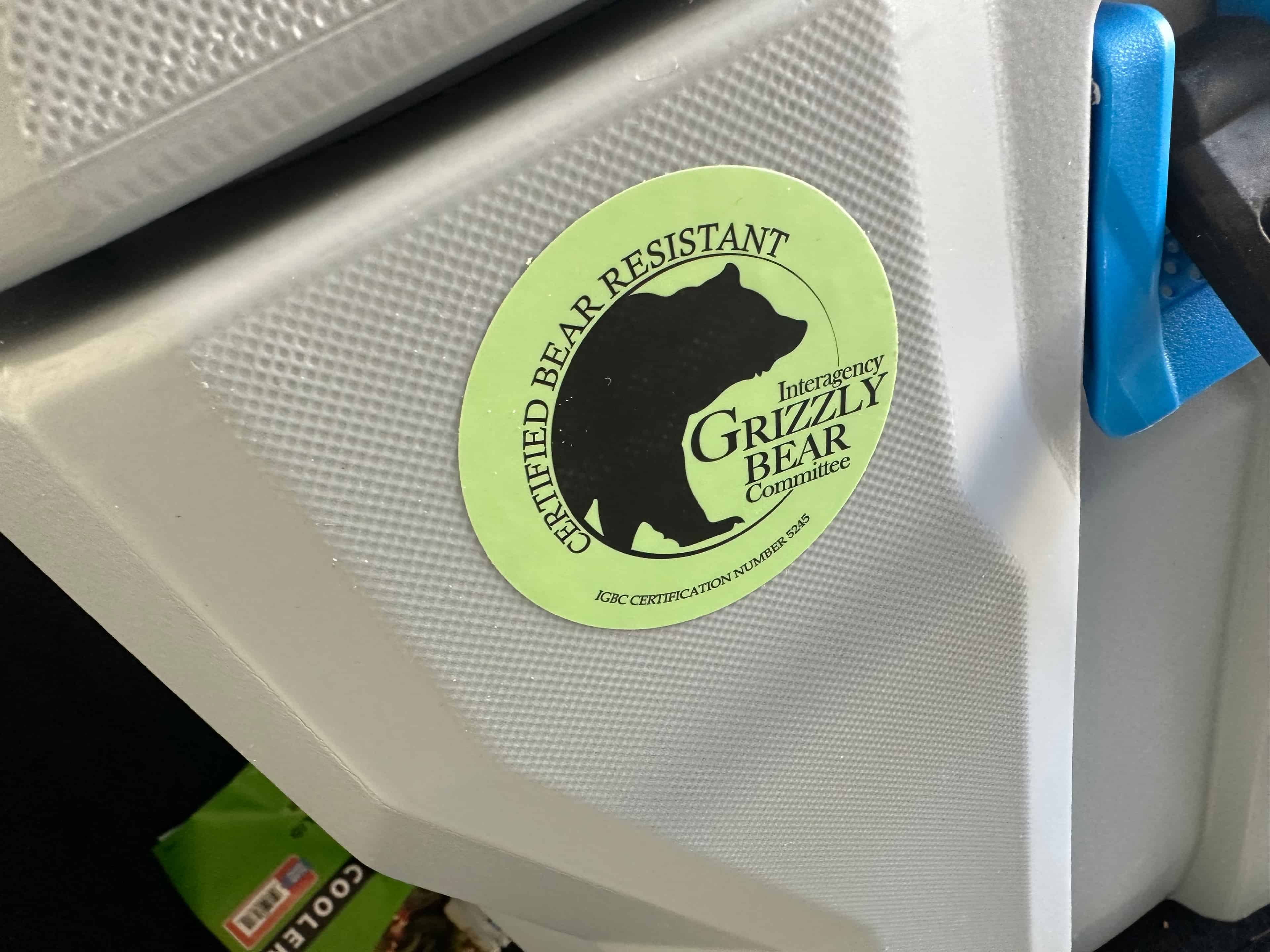 Lifetime 77 QT High Performance -kylmälaukku kestää karhun käsittelyn. Valmistaja lupaa, että Lifetime 77 QT High Performance -kylmälaukku kesää myös karhun käsittelyn. Boksin kylkeen on liimattu tästä kertova tarrra.