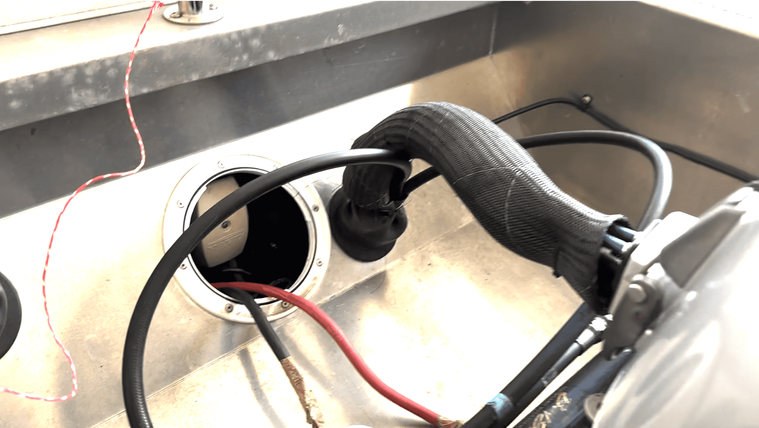 Tarkastusluukku Faster 460 perässä Takakulmasta tuodut kaapelit vedettynä veneen keskelle perään tarkastusluukusta ulos. Tarkastusluukun alla on suoraan asennusputki kohti pulpettia.